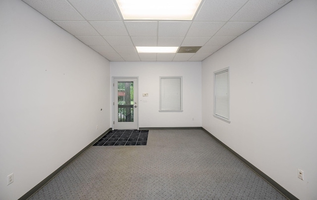 carpeted empty room with a paneled ceiling