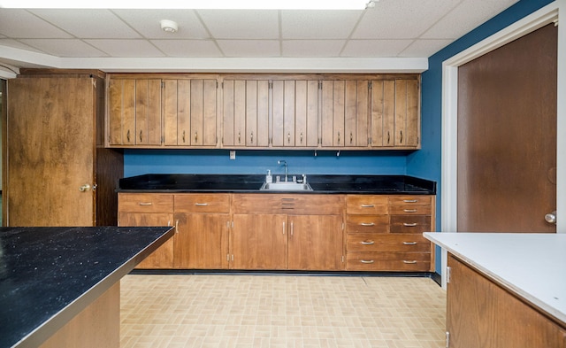 kitchen with a paneled ceiling and sink