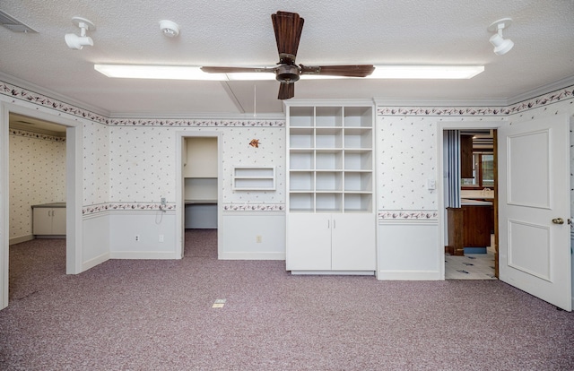 unfurnished bedroom with ceiling fan, carpet, and a textured ceiling