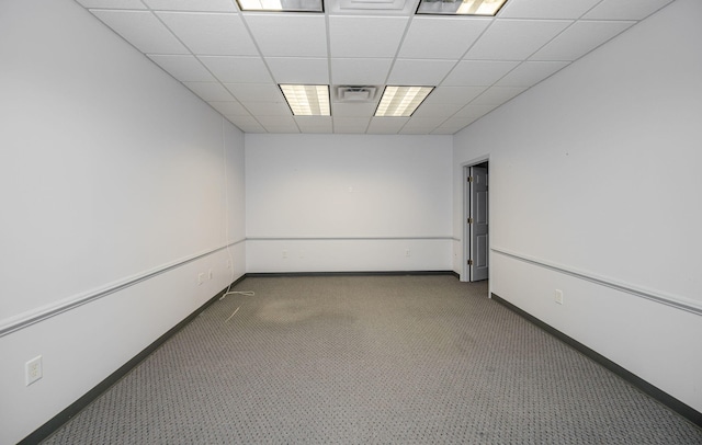 unfurnished room with a drop ceiling, dark carpet, and a baseboard radiator