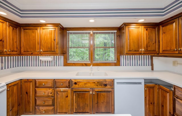 kitchen featuring white dishwasher, crown molding, and sink