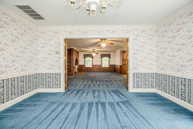 empty room with carpet flooring, ceiling fan with notable chandelier, and crown molding