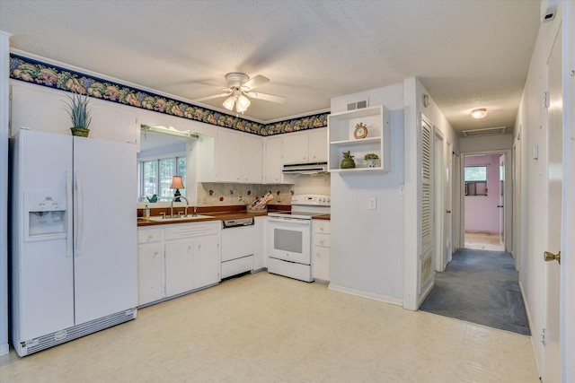 kitchen with white appliances, white cabinets, sink, ceiling fan, and a textured ceiling