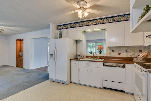 kitchen with a textured ceiling, white appliances, ceiling fan, sink, and white cabinetry