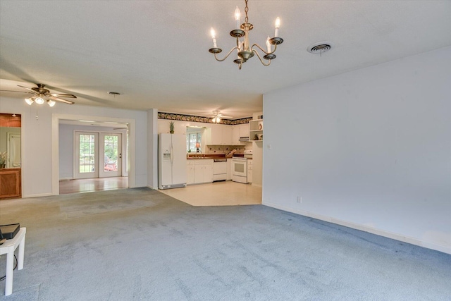 unfurnished living room with a textured ceiling, light colored carpet, and ceiling fan with notable chandelier