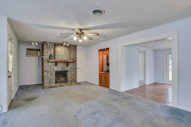 unfurnished living room with carpet floors, a stone fireplace, and ceiling fan