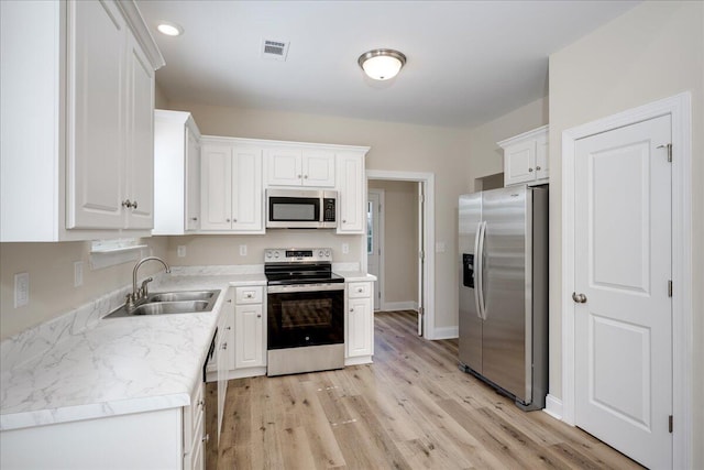 4921 Mossycup Ct, Hephzibah, GA 30815 - kitchen with appliances with stainless steel finishes, white cabinetry, light wood finished floors, light countertops, and recessed lighting