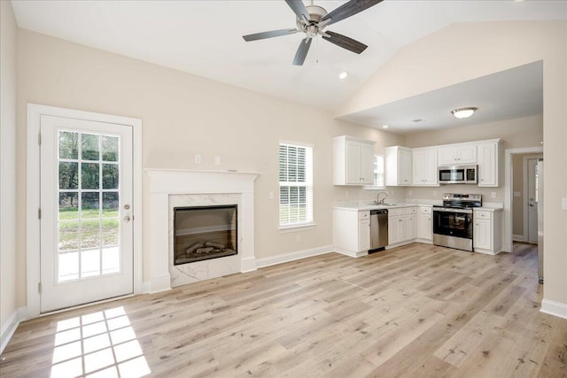 4921 Mossycup Ct, Hephzibah, GA 30815 - kitchen featuring stainless steel appliances, light countertops, lofted ceiling, white cabinetry, and light wood finished floors