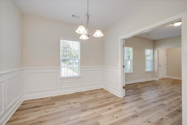 4921 Mossycup Ct, Hephzibah, GA 30815 - empty room featuring a chandelier, a wainscoted wall, light wood-type flooring, and a decorative wall