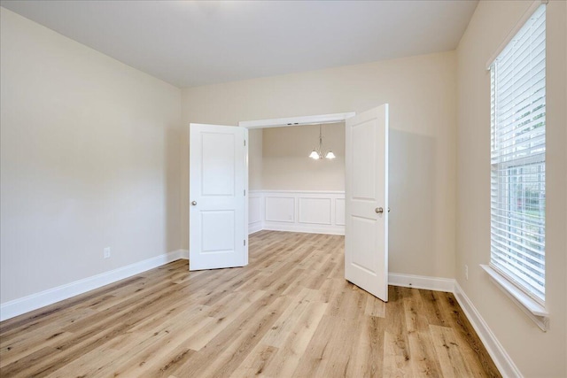 4921 Mossycup Ct, Hephzibah, GA 30815 - unfurnished bedroom with a chandelier, light wood-type flooring, and wainscoting