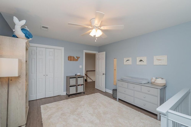 bedroom featuring visible vents, baseboards, wood finished floors, a closet, and a ceiling fan