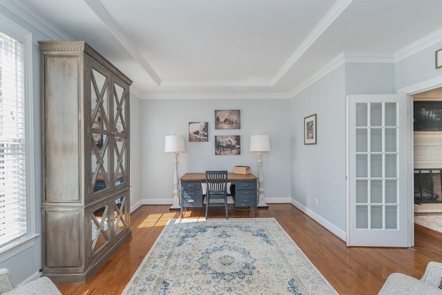 office area with baseboards, wood finished floors, and ornamental molding