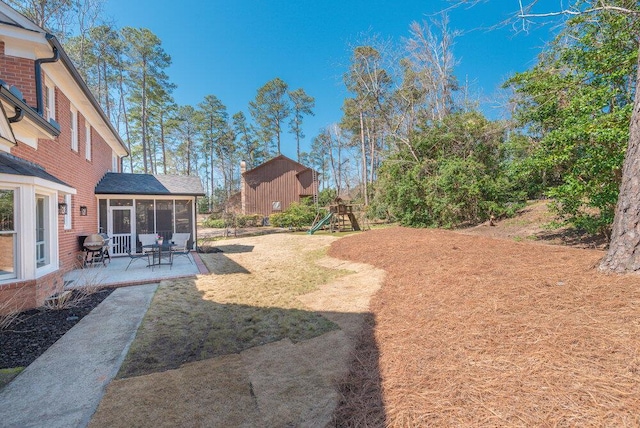 view of yard featuring a patio area, a sunroom, and a playground