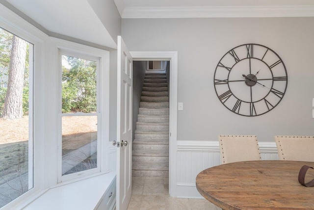 stairway featuring a wainscoted wall and crown molding