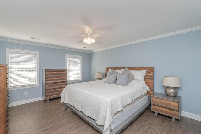 bedroom with visible vents, wood finished floors, and crown molding