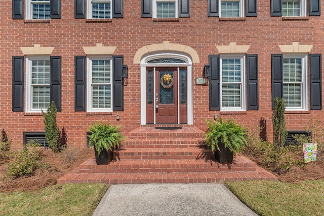 doorway to property featuring brick siding