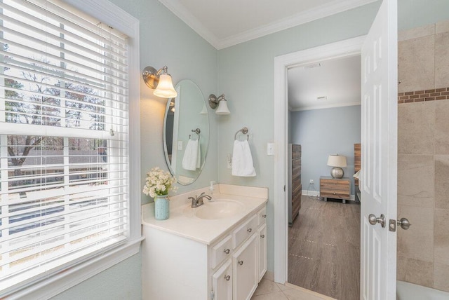 full bathroom with a wealth of natural light, baseboards, vanity, and crown molding