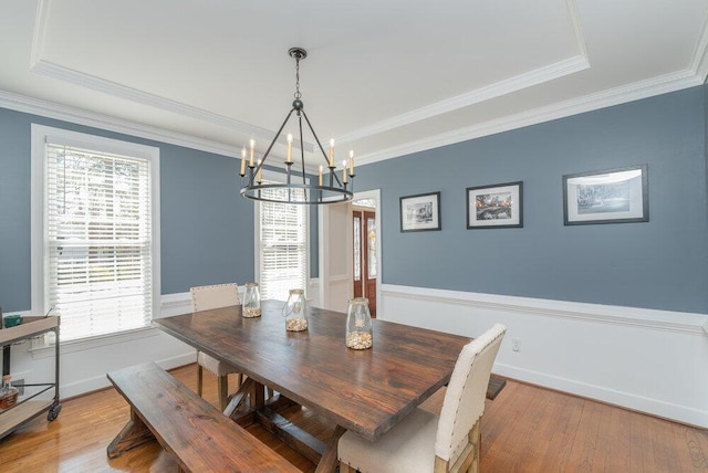 dining room with an inviting chandelier, crown molding, and wood finished floors