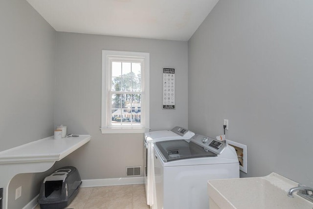 laundry area with independent washer and dryer, a sink, light tile patterned floors, baseboards, and laundry area