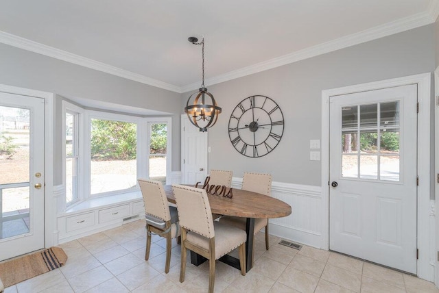 dining room featuring visible vents, ornamental molding, plenty of natural light, an inviting chandelier, and wainscoting