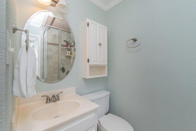 bathroom with vanity, toilet, ornamental molding, and a shower stall