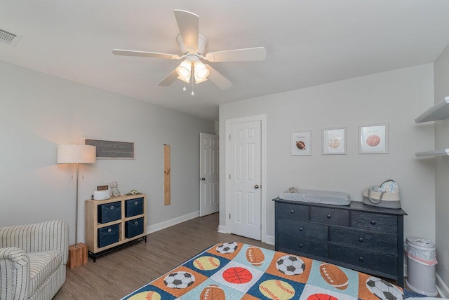 bedroom with visible vents, wood finished floors, baseboards, and ceiling fan