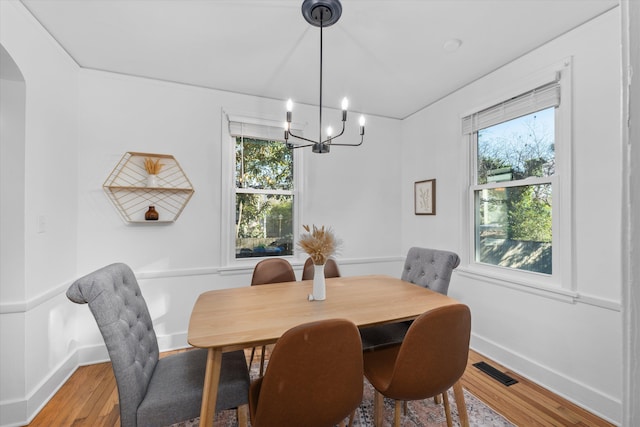 1738 Kissingbower Rd, Augusta, GA 30904 - dining space featuring a chandelier, light wood-style floors, and arched walkways