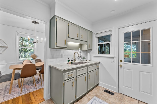 1738 Kissingbower Rd, Augusta, GA 30904 - kitchen with gray cabinetry, crown molding, plenty of natural light, and tasteful backsplash