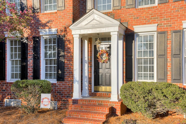 doorway to property featuring brick siding