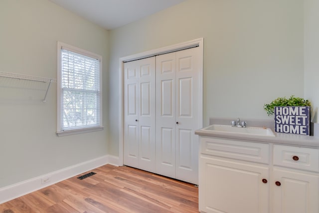 bathroom featuring wood finished floors, vanity, visible vents, baseboards, and a closet