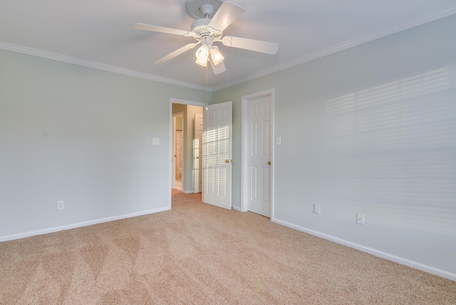 unfurnished room featuring baseboards, carpet flooring, a ceiling fan, and crown molding