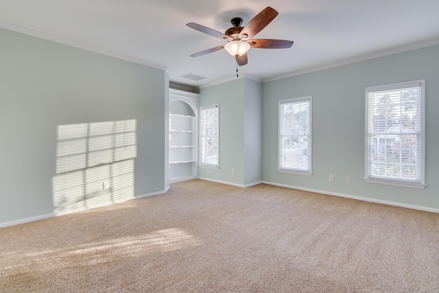 spare room with ornamental molding, visible vents, carpet floors, and baseboards