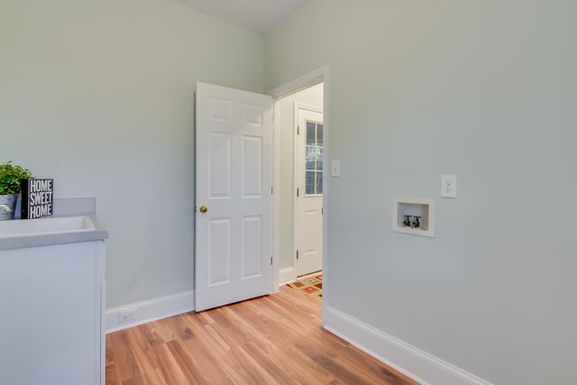 laundry room with hookup for a washing machine, light wood-type flooring, laundry area, and baseboards