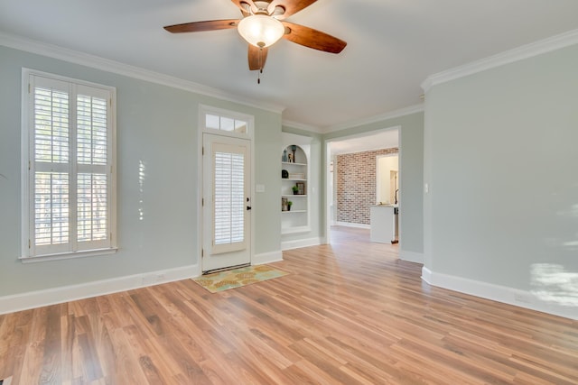 entrance foyer with ornamental molding, ceiling fan, light wood-style flooring, and baseboards