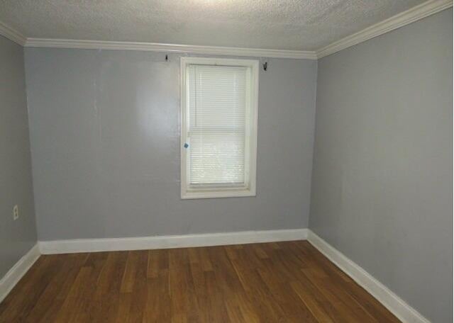 unfurnished room with a textured ceiling, dark hardwood / wood-style flooring, and crown molding