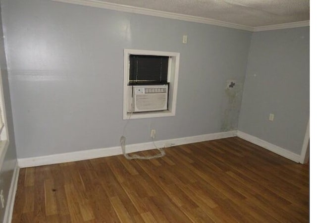 unfurnished room with a textured ceiling and dark hardwood / wood-style floors