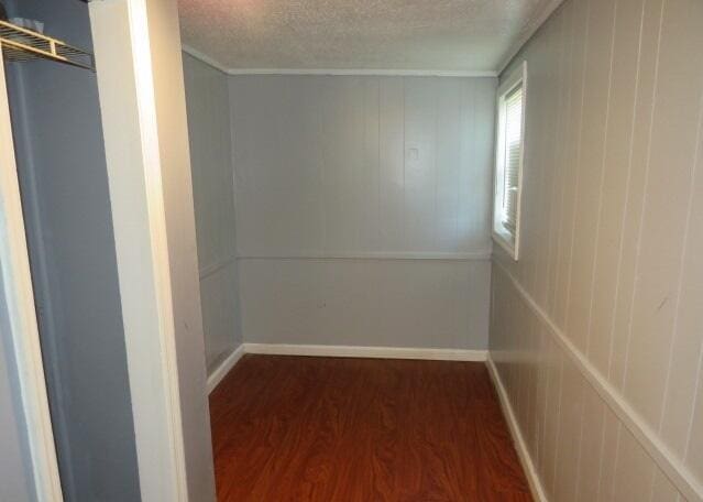 corridor featuring dark hardwood / wood-style flooring and a textured ceiling