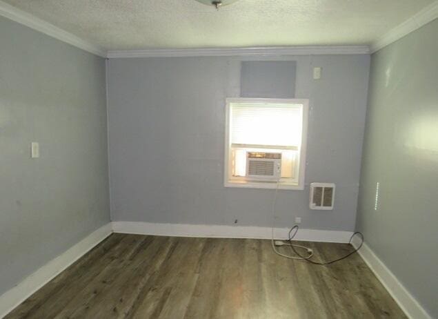 spare room with dark hardwood / wood-style floors, cooling unit, and ornamental molding