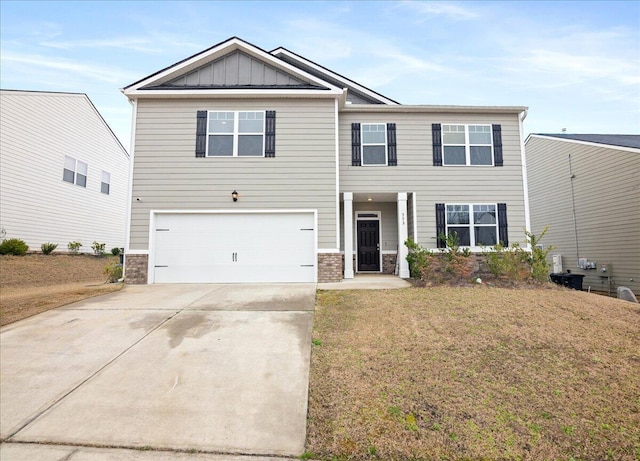 craftsman house featuring an attached garage, a front lawn, board and batten siding, and concrete driveway