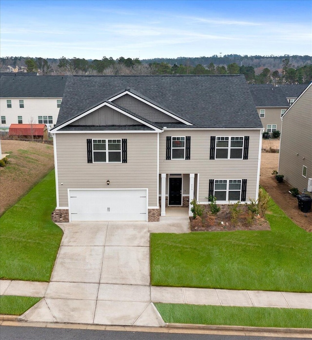 view of front of home with a garage, driveway, board and batten siding, and a front lawn