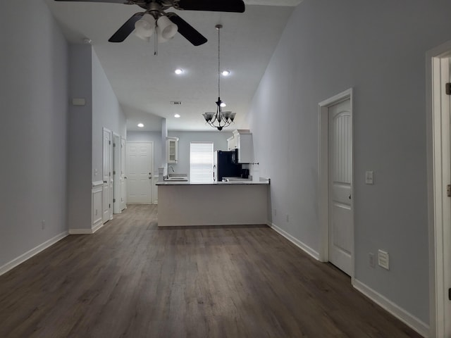 unfurnished living room with baseboards, recessed lighting, ceiling fan with notable chandelier, a sink, and dark wood-style floors