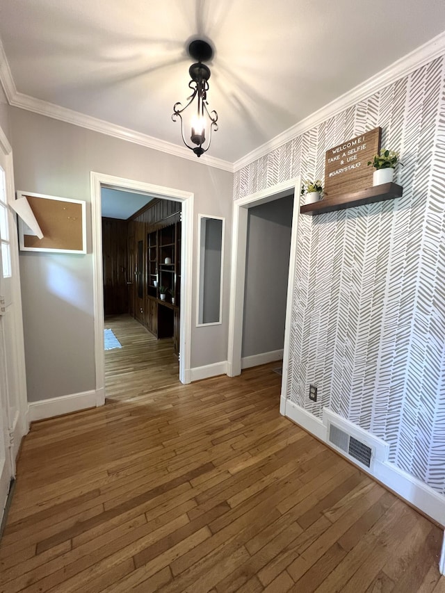 unfurnished dining area featuring hardwood / wood-style floors and ornamental molding