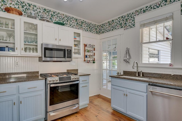 1958 Mcdowell St, Augusta, GA 30904 - kitchen featuring appliances with stainless steel finishes, ornamental molding, light wood finished floors, white cabinets, and a sink