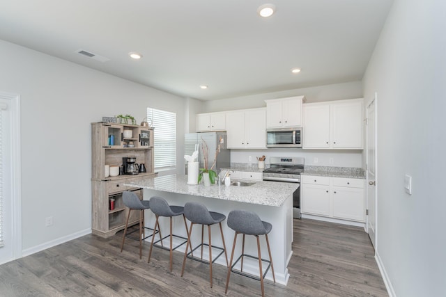 6058 Whitewater Dr, North Augusta, SC 29841 - kitchen with stainless steel appliances, a kitchen breakfast bar, white cabinets, dark wood finished floors, and recessed lighting