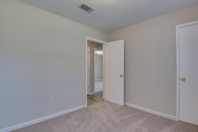 carpeted spare room with a textured ceiling