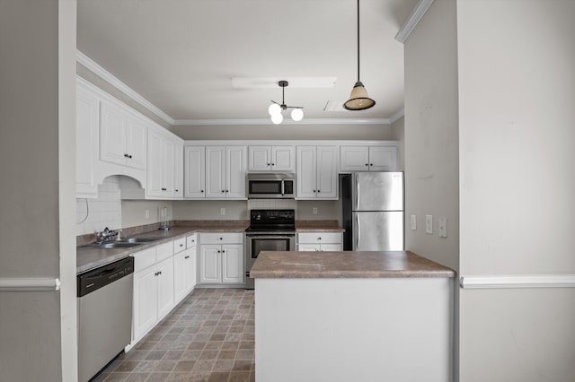 2807 Brickrun Way, Augusta, GA 30909 - kitchen featuring appliances with stainless steel finishes, crown molding, white cabinetry, a peninsula, and hanging light fixtures