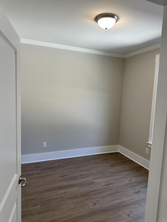 spare room featuring baseboards, dark wood-style floors, and crown molding