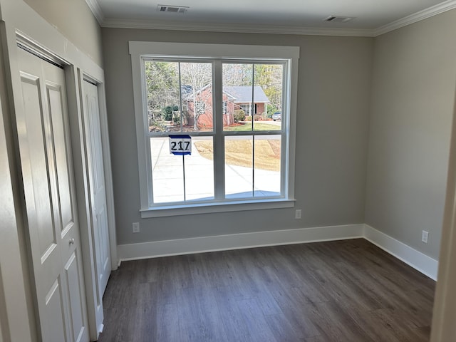 unfurnished room featuring dark wood finished floors, plenty of natural light, baseboards, and ornamental molding