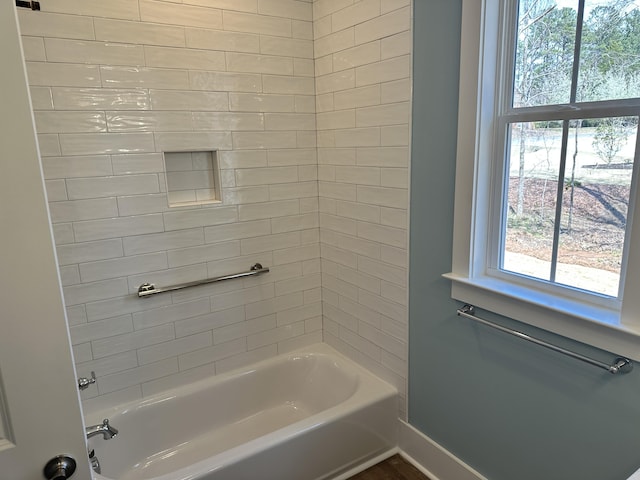 bathroom with tub / shower combination and baseboards