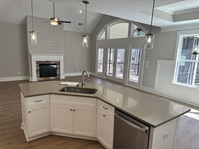 kitchen featuring a fireplace, dark wood-style flooring, a sink, dishwasher, and open floor plan